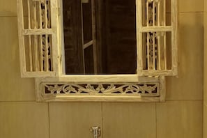 Ein Fenster mit aufwendig gestalteten weißen Rahmen und einem verzierten Gitter.