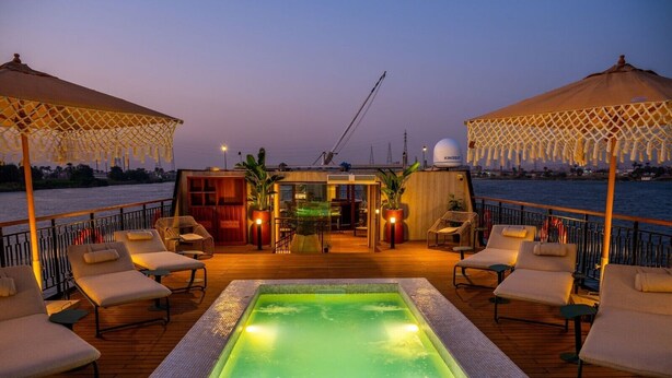 A deck with a hot tub, lounge chairs, and umbrellas. - Sonesta Dahabeya Amirat II - Nile Cruise Ship - 4 nights from Luxor (Luxor)