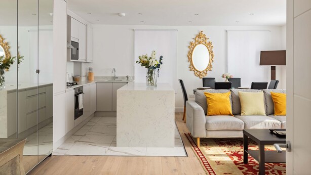 A modern apartment with a kitchen, dining area, and living room.