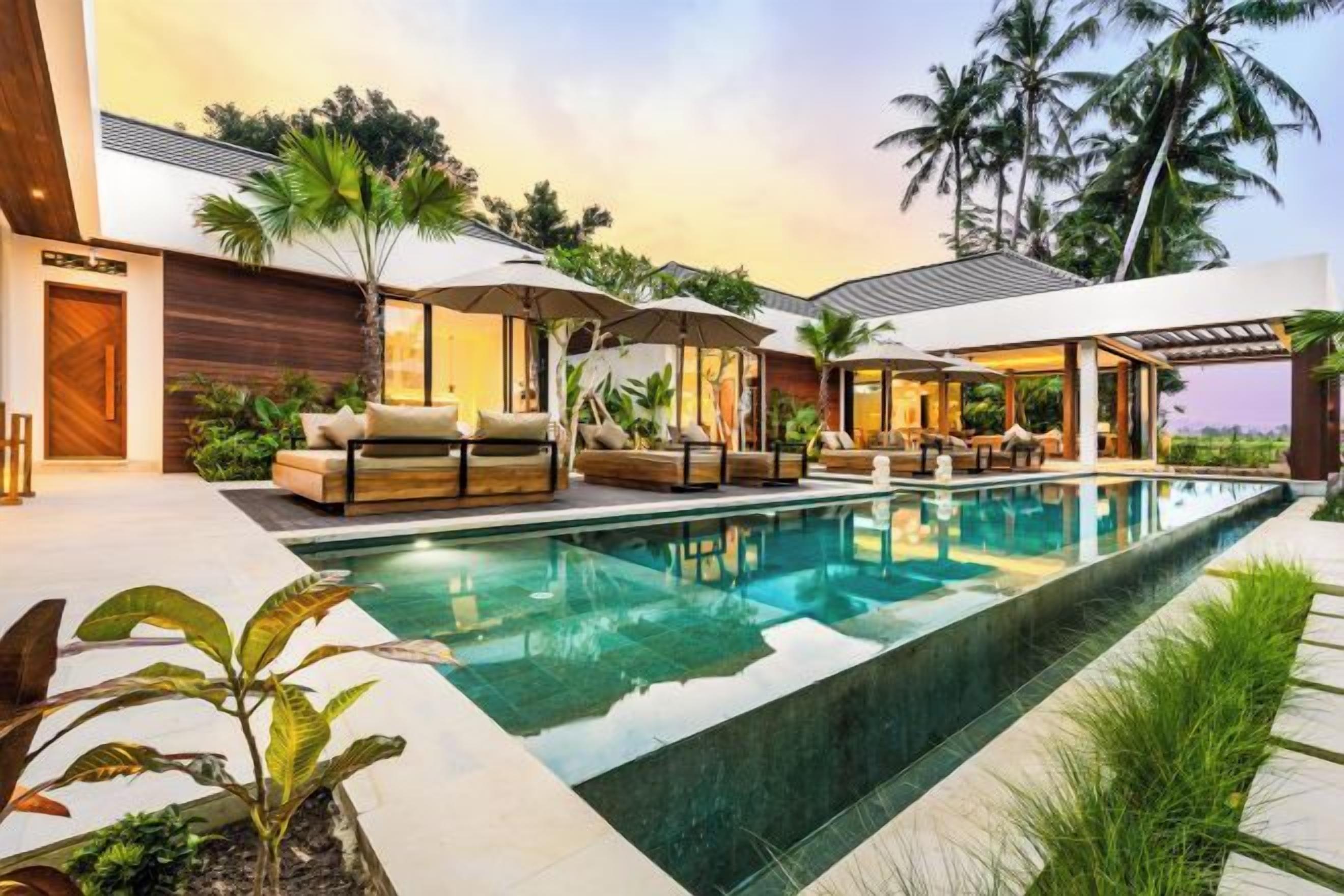 A modern poolside area with lounge chairs, umbrellas, and a clear pool.