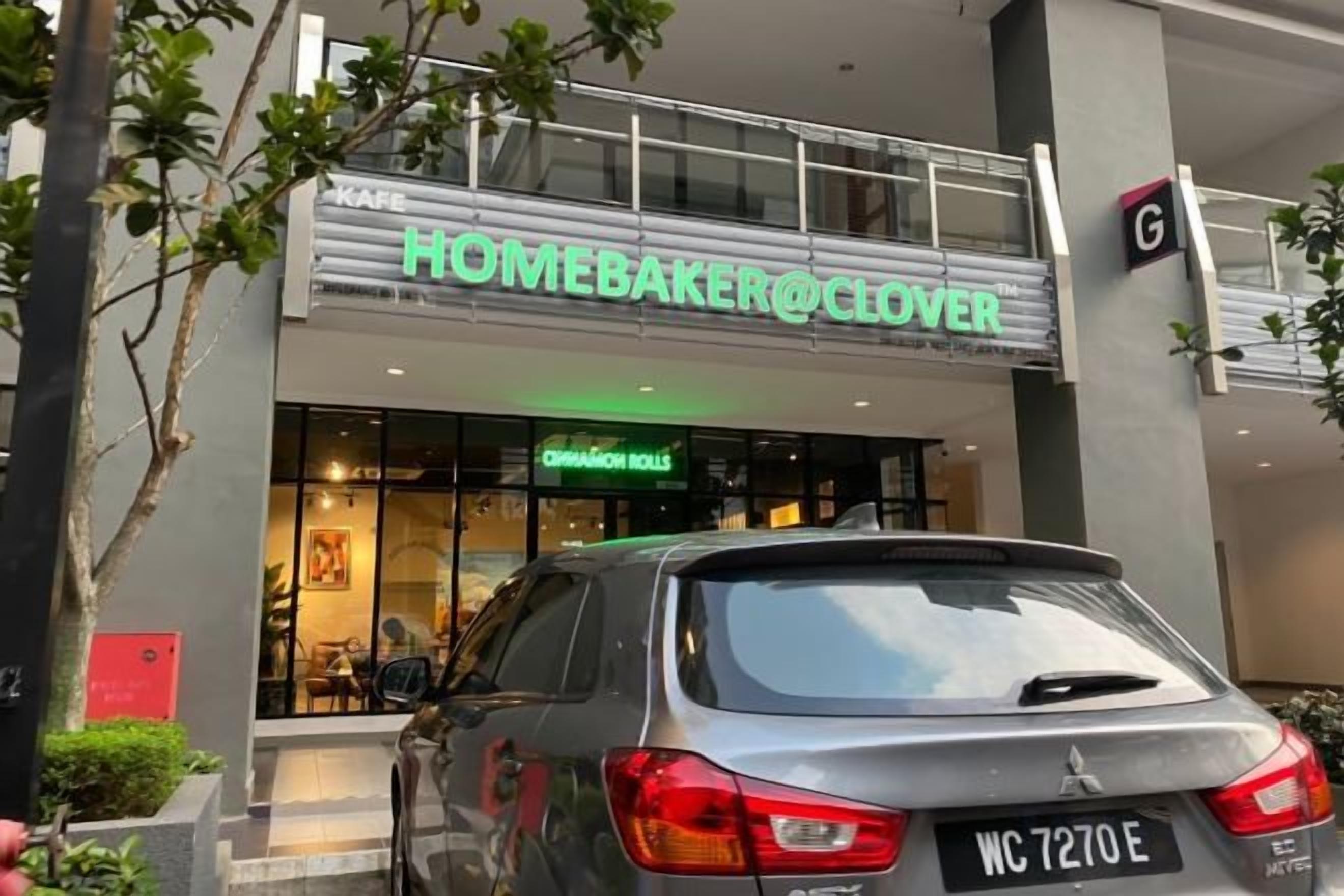A storefront with a sign reading 'HOMEBAKER@CLOVER' and a car parked in front.