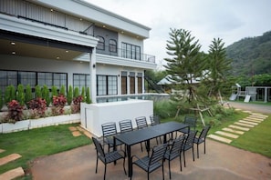 A modern two-story house with a patio, outdoor seating, and a mountain backdrop. - Tierra en Sierra (Pak Chong)