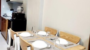 Een eetgedeelte met een rechthoekige tafel gedekt voor vier personen, omringd door houten stoelen.