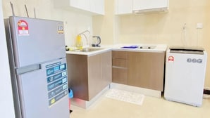 Eine kleine Küche mit Kühlschrank, Mikrowelle, Spüle und Geschirrspüler.