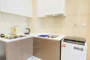 Une cuisine équipée d’un évier à deux bacs, d’une machine à café et d’un lave-vaisselle compact.