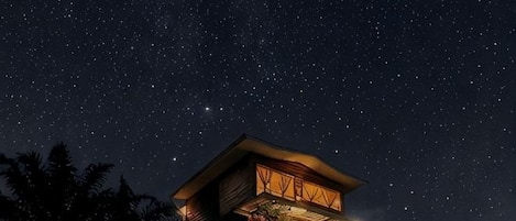 Un edificio de varios pisos con un cielo estrellado al fondo.