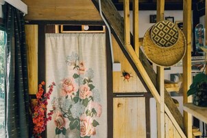 Una escalera con barandilla de madera y un sombrero decorativo colgado en la pared.