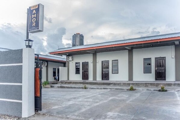 A building with a sign reading 'AMOR' and a covered parking area.