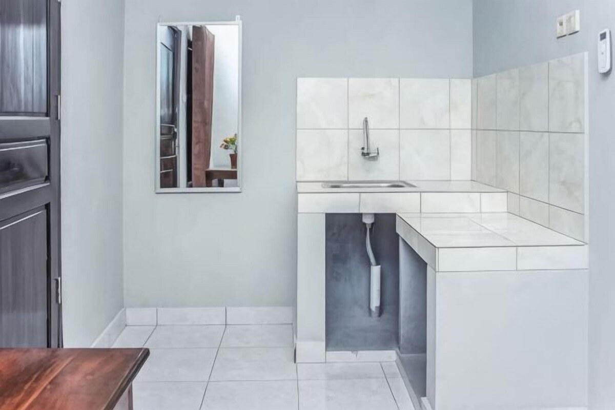 Una cocina moderna con un lavaplatos integrado, un espejo y una mesa de madera.