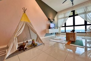A room with a tent, a television, a sofa, and a view of the sea. - Paradigm Mall Residence L30 By Ucome Homestay (Tebrau)