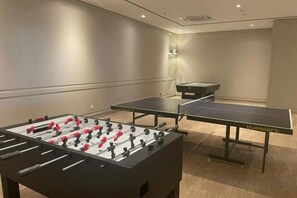 A room with a foosball table, a ping pong table, and a small table tennis table. - Paradigm Mall Residence L30 By Ucome Homestay (Tebrau)