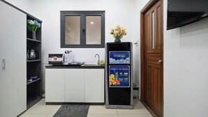 Una cocina compacta con microondas, lavamanos y refrigerador con un anuncio azul.