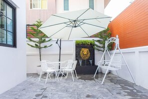 A patio with a white umbrella, white chairs, and a small table. - Luxury Private Pool Villa "Psalms 23 Residence @Huaikwang" (Bangkok)