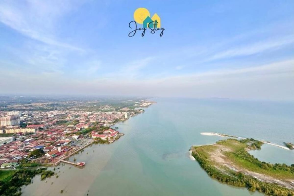 An aerial view of a coastal city with a marina, buildings, and a large body of water.