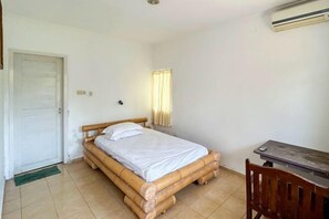 Una stanza con un letto, una scrivania e una porta.