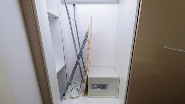 Un baño pequeño y cerrado con inodoro, lavamanos y zona de ducha.