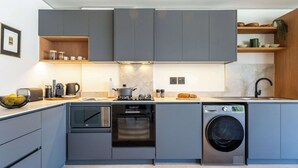 Eine moderne Küche mit grauen Schränken, einem Backofen, einer Mikrowelle und einem Geschirrspüler.