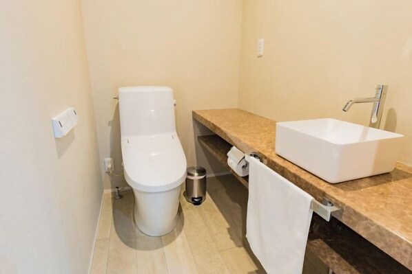 A small bathroom with a toilet, a sink, and a towel rack. - Amber Yufuin (Yufu)