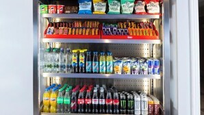 En försäljningsautomat fylld med olika sorters snacks och drycker.