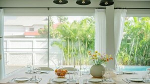 A dining table set for six with white plates, glasses, and a centerpiece of flowers. - Private Pool Villa 6 Bedroom - Cloud Nine Villa (Chiang Mai)