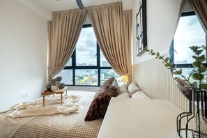 A hotel room with a large window, a bed, a bedside table, and a view of the city. - CUBIC BOTANICAL BY FEEL HOME (Kuala Lumpur)