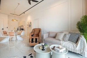A modern living room with a sofa, coffee table, and a massage chair. - CUBIC BOTANICAL BY FEEL HOME (Kuala Lumpur)