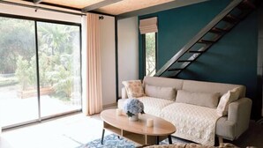 Ein modernes Wohnzimmer mit einer Couch, einem Couchtisch und einer Treppe.