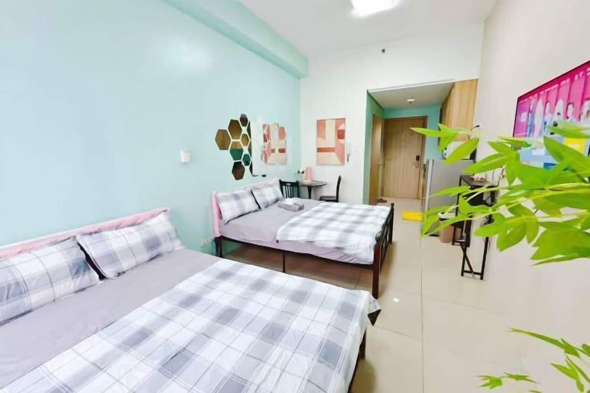 A room with two beds, a desk, and a chair.