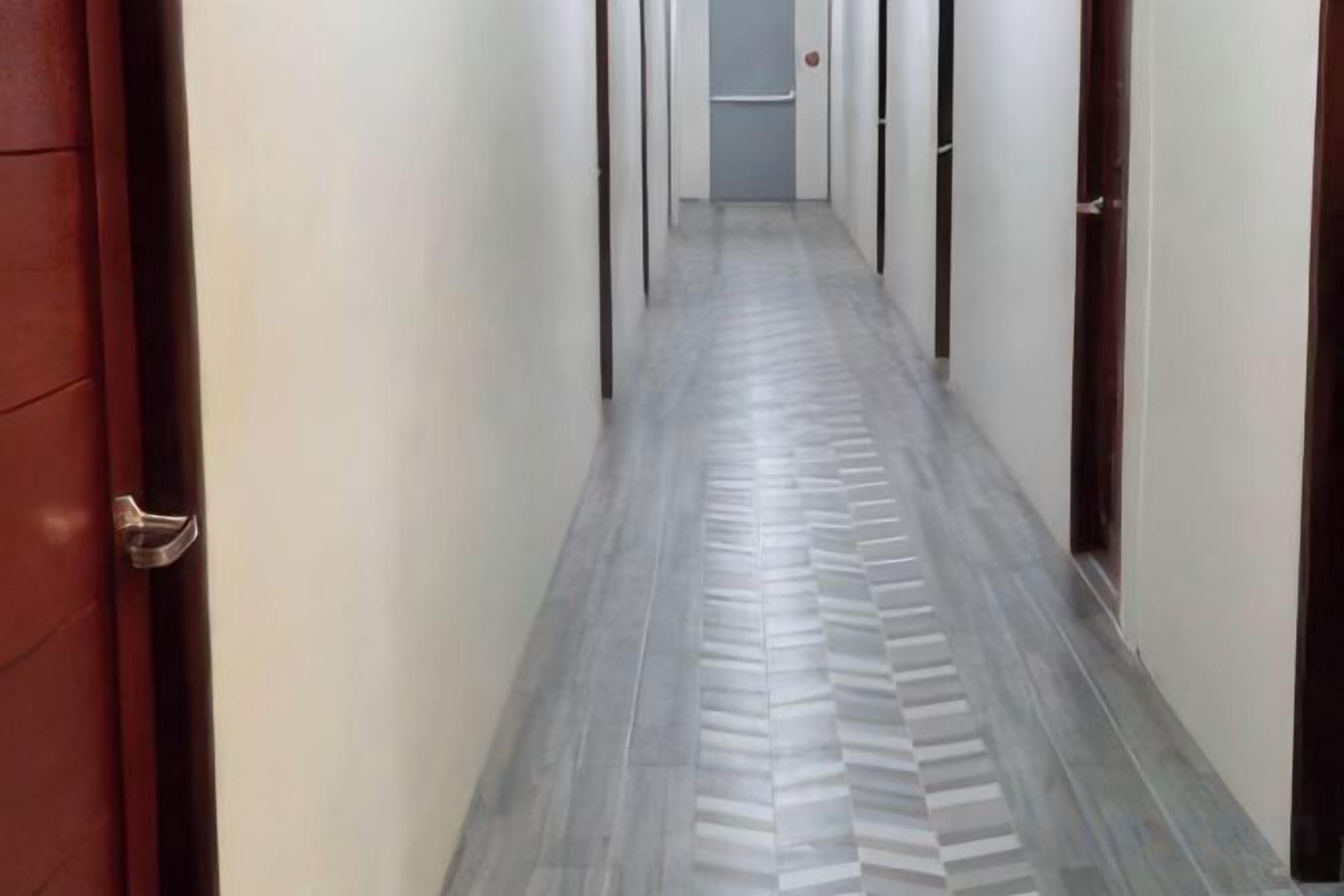 A hallway with a patterned floor and doors on either side.