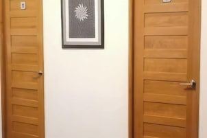 Dos puertas de madera con un cuadro enmarcado de una flor entre ellas.