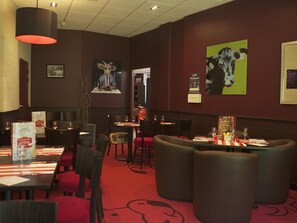 A restaurant interior with tables, chairs, and artwork on the walls. - Ibis Villepinte Parc Expos (Villepinte)