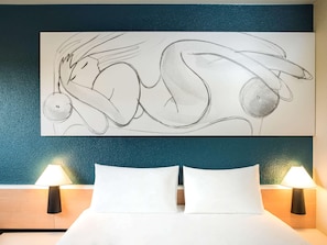 A hotel room with a bed, two bedside lamps, and a large abstract painting on the wall. - Ibis Villepinte Parc Expos (Villepinte)