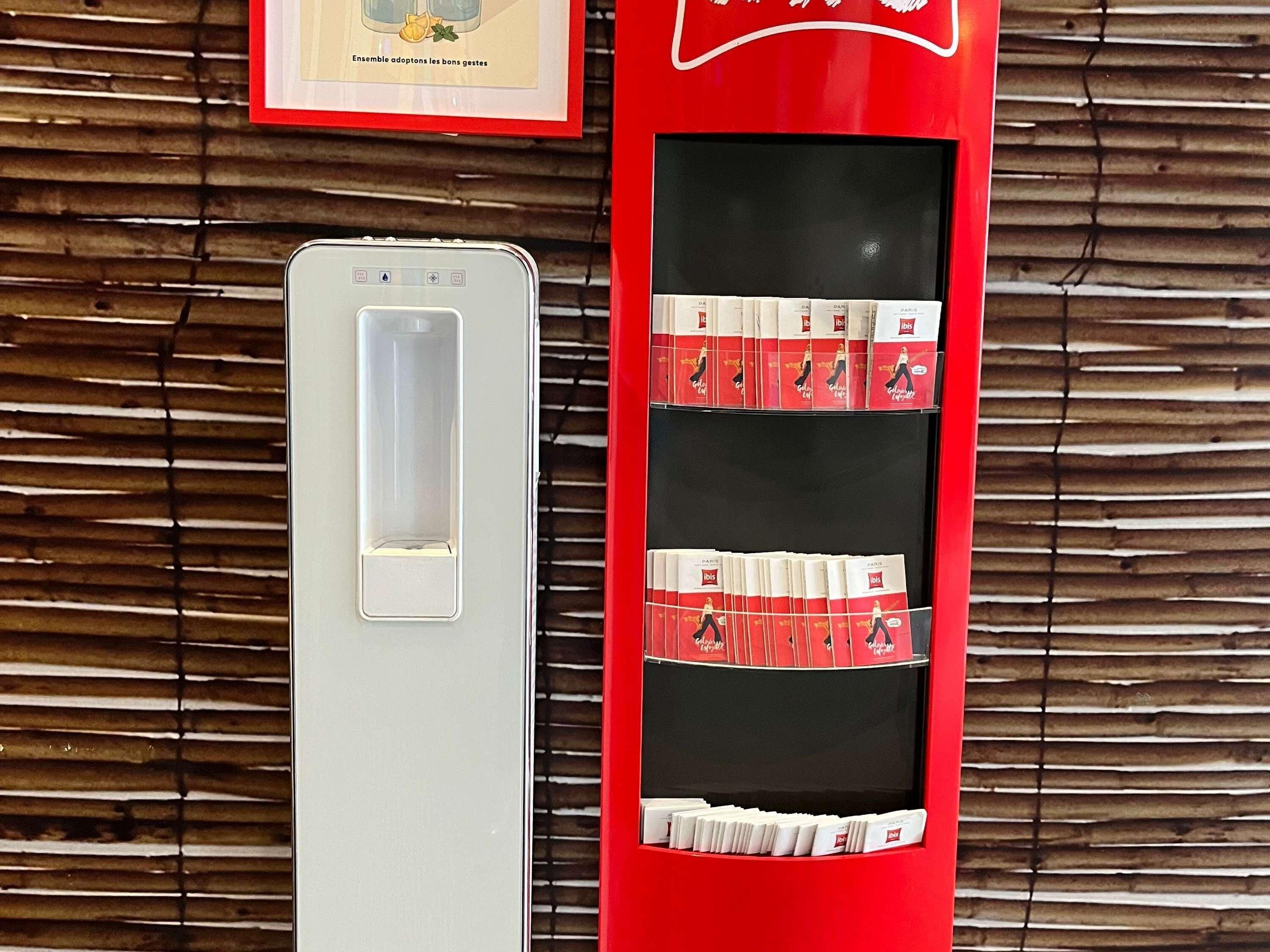 Máquina expendedora con libros y un cuadro en una pared de madera.