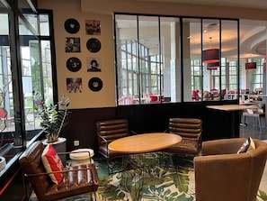 Un interior moderno con una mesa redonda, sillas de cuero y una pared decorada con discos de vinilo.