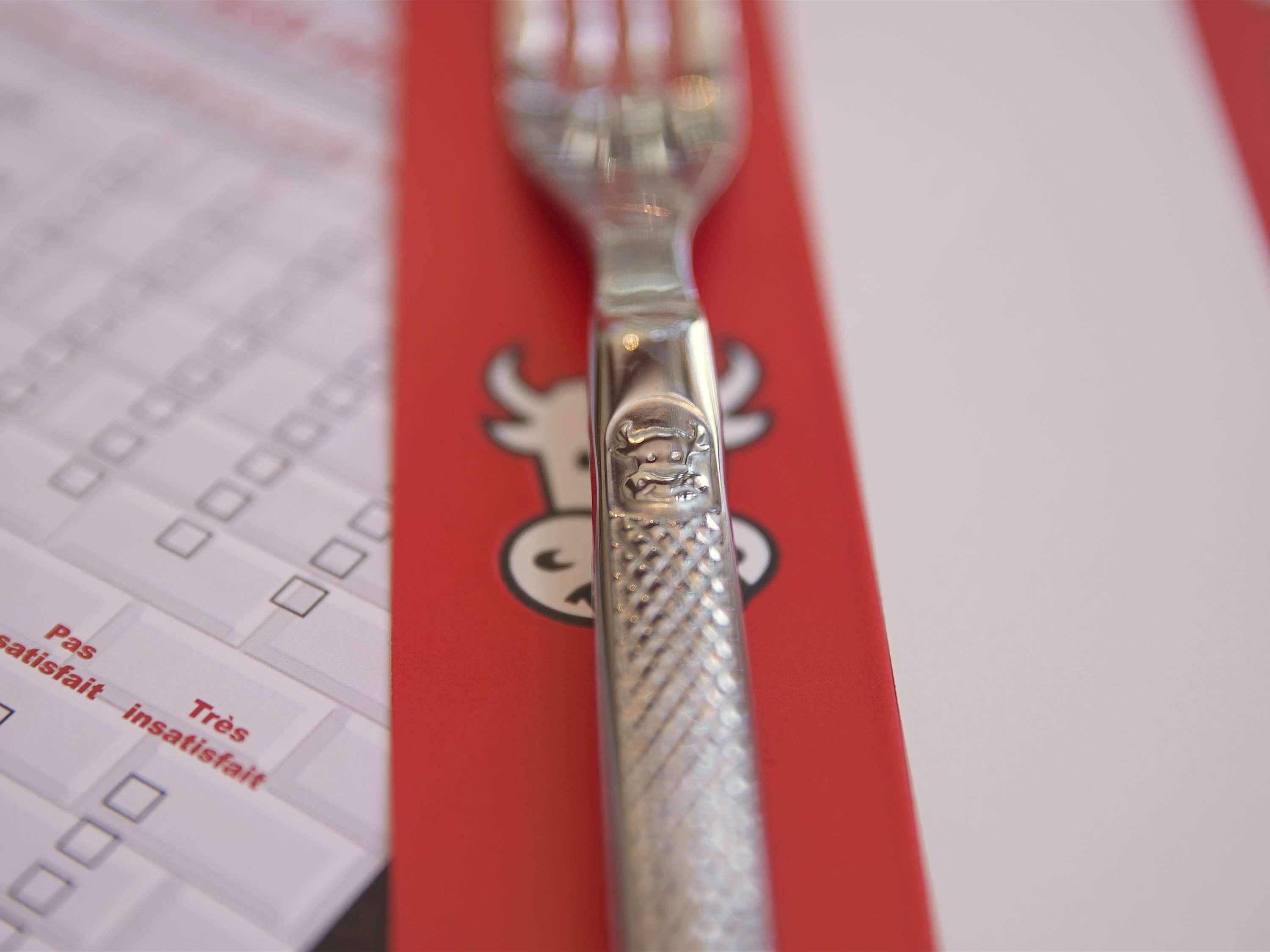 Un tenedor con mango decorativo y una servilleta roja con un personaje de caricatura.