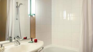 A bathroom with a white sink, mirror, and shower.