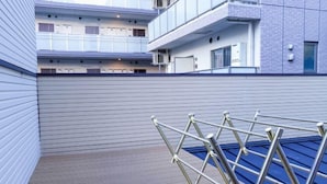 A modern building with a flat roof and a metal drying rack. - hoshino homestay (Osaka)