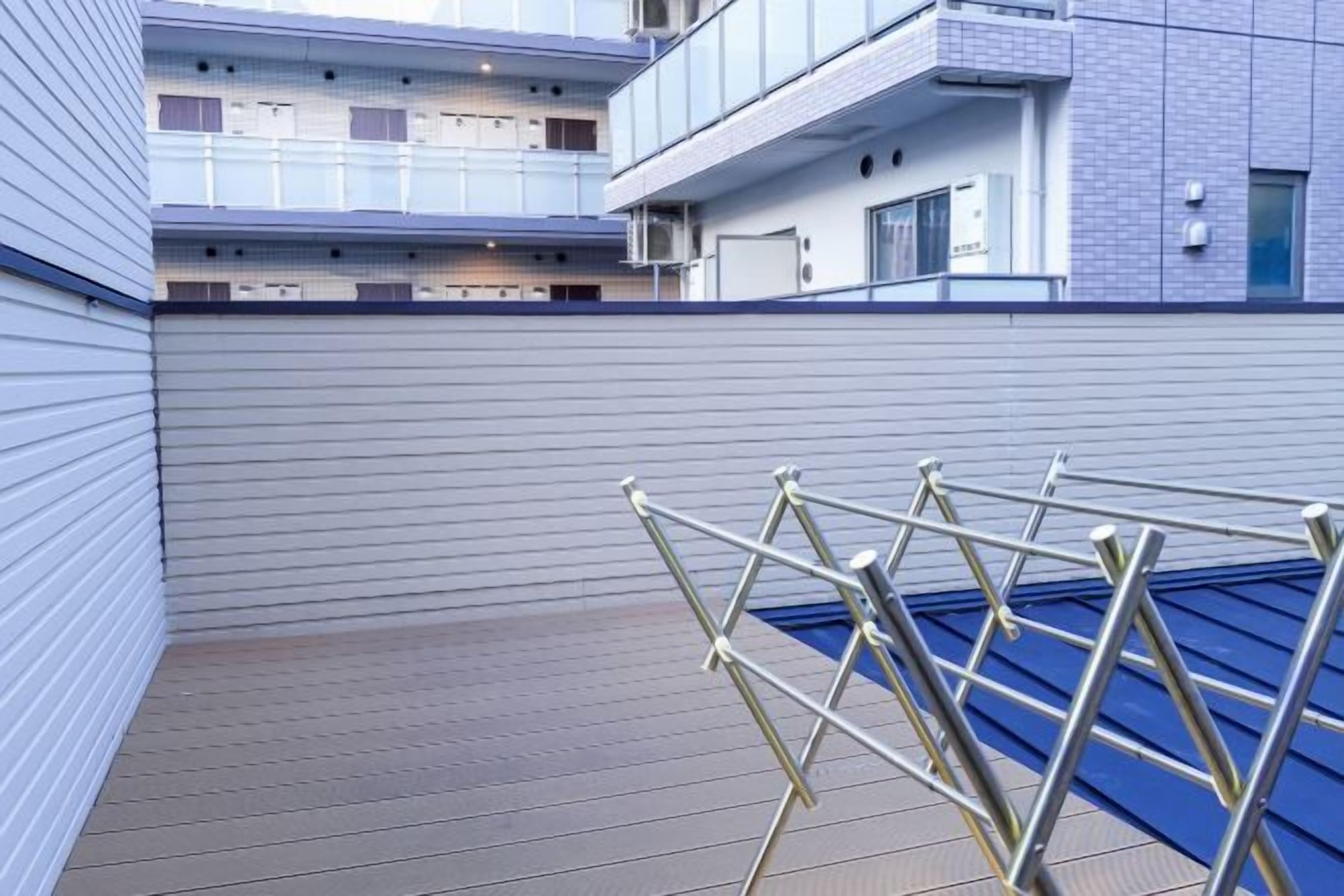 A modern building with a flat roof and a metal drying rack.