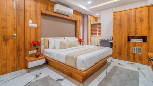 A modern bedroom with a wooden bed frame, a bedside table with a vase of flowers, and a built-in wardrobe. - Hotel Deol's Paradise (Indore)