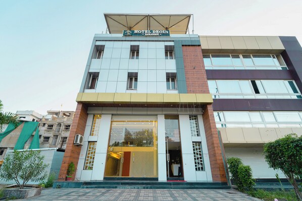 Un hotel con fachada moderna, amplios ventanales de vidrio y una entrada destacada.