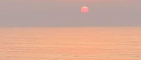 Atardecer sobre un mar tranquilo con cielo despejado.