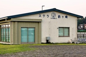 Ein Gebäude mit einem Schild, auf dem 'Stella Ichinomiya' steht, und einem großen Glastür-Eingang.