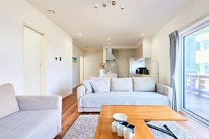 Un salon moderne avec un canapé, une table basse et une vue sur l’extérieur.