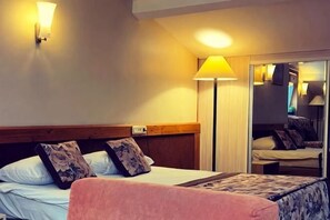 A hotel room with a bed, bedside lamp, and a mirror. - Haydarpasa Hotel (Istanbul)