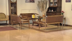 A room with a wooden sofa, two armchairs, a glass coffee table, and a bookshelf. - Haydarpasa Hotel (Istanbul)