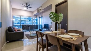 A dining area with a table set for four, a sofa, a ceiling fan, and a view of the outside. - ELEMENT BY FEEL HOME(The elements@Ampang) (Kuala Lumpur)