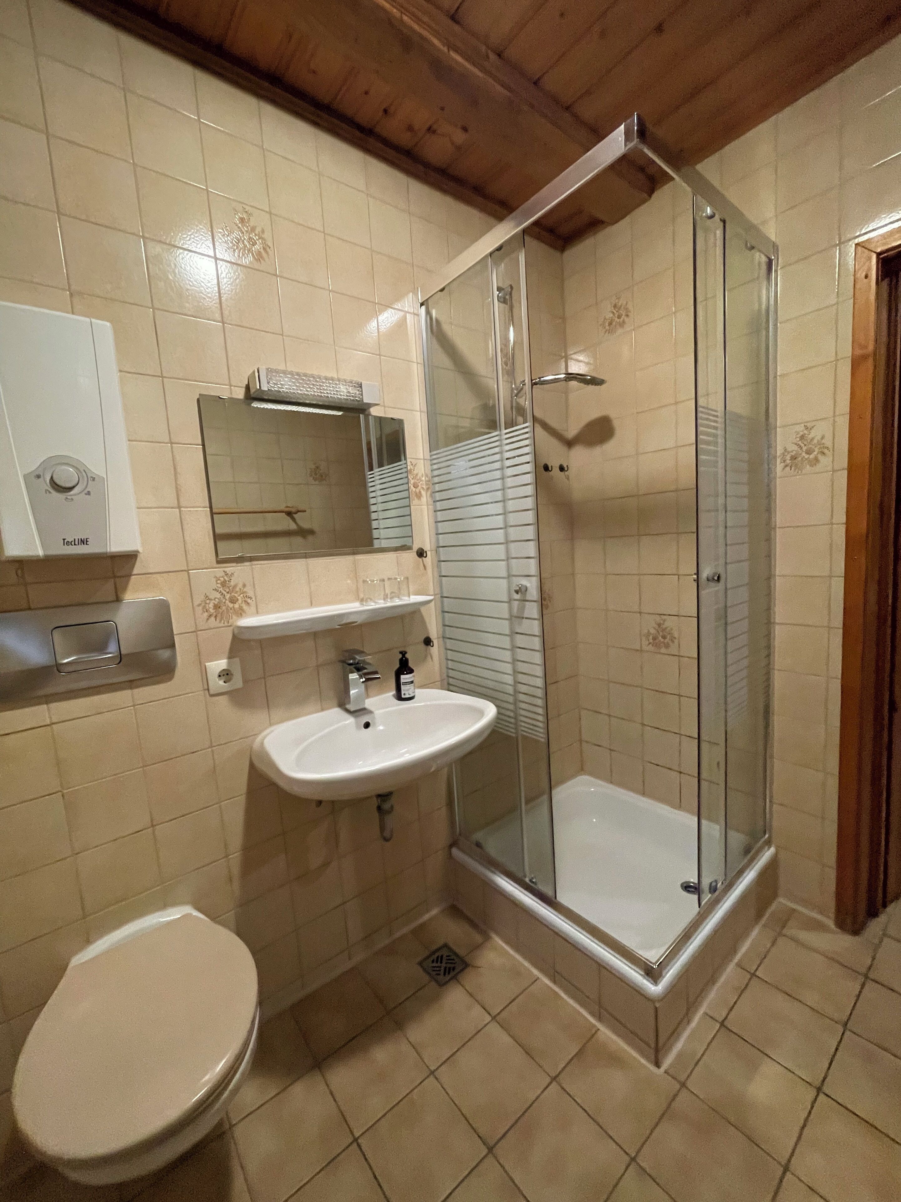 Une salle de bain équipée de toilettes, d’un lavabo et d’une douche à parois de verre.