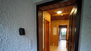 A hallway with a 'welcome' mat leading to a wooden door. - Schönblick B8 House · Mountain Charm with a View of Nature (Schöfweg)