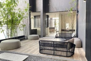 A modern interior with seating, a wooden floor, and indoor plants. - Bukit Bintang Lalaport Designer Studio KLCC View (Kuala Lumpur)