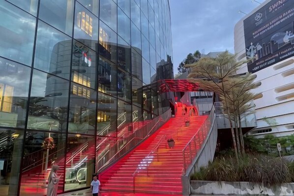 A modern building with a glass facade and a red-lit staircase.